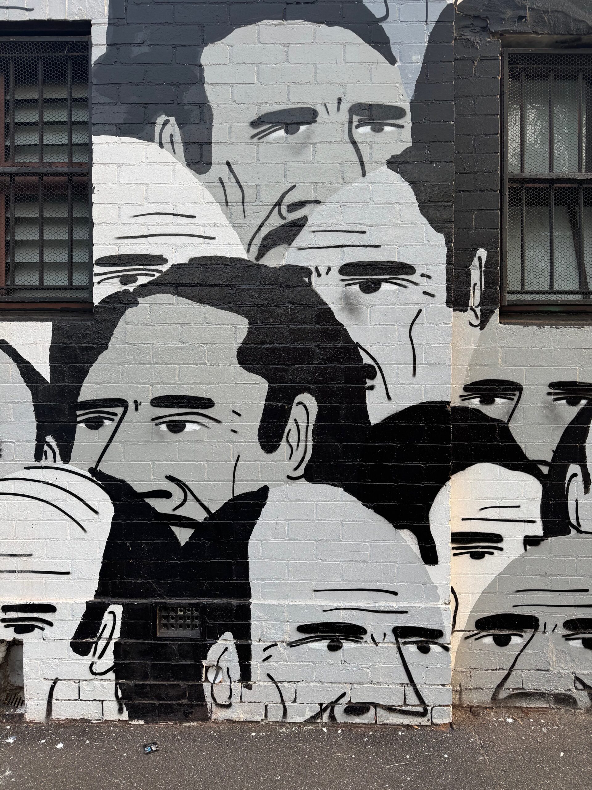 Black and white street art mural of faces